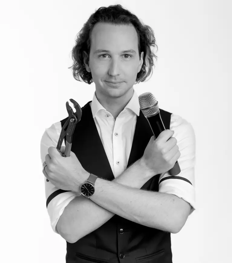 Kilian Hein mit Mikrofon und Zange als Symbole für Präsentationstechnik